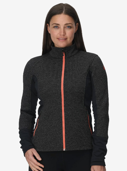 A person wearing a fitted, dark gray athletic jacket with orange zipper details, showcasing a sporty style.