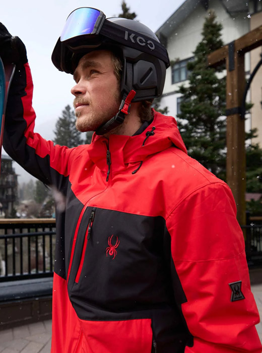 Skier wearing a red and black ski jacket.