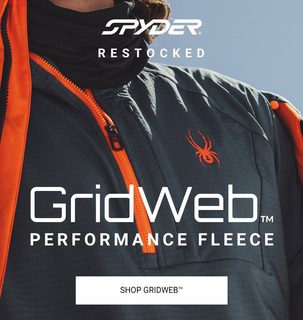 Close-up of a person wearing a slate blue and orange Spyder GridWeb™ performance fleece jacket, with the Spyder logo. Shop Gridweb™