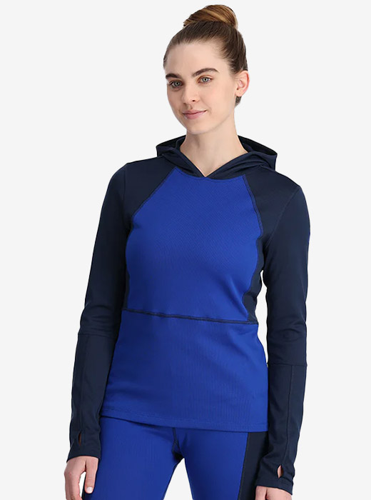 Woman in studio wearing a navy and cobalt blue Spyder baselayer