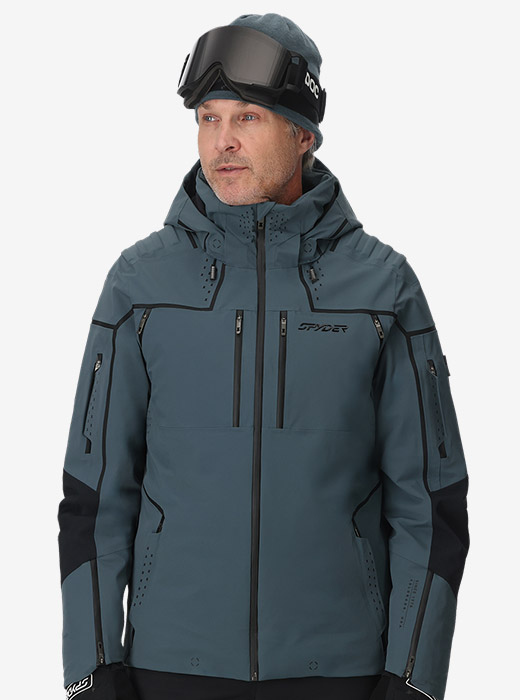 Studio image of model wearing a slate blue Pinnacle Jacket