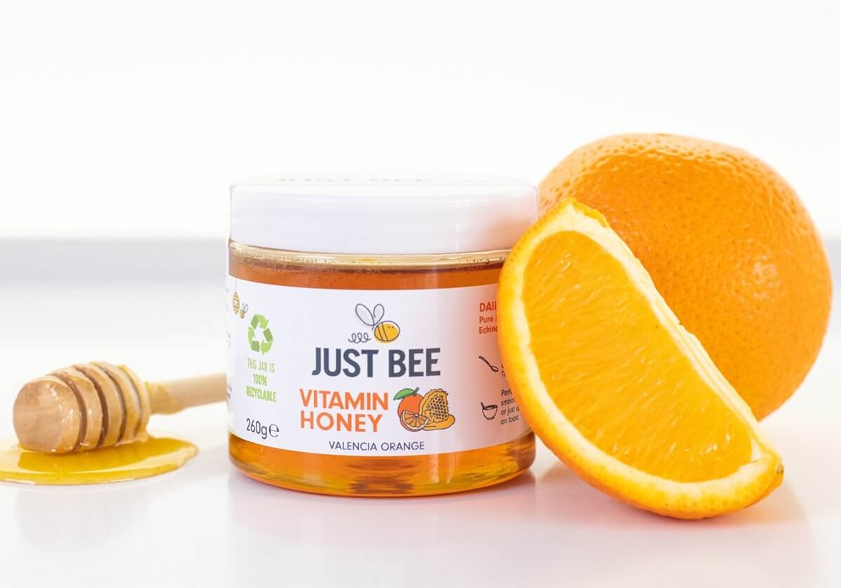 Valencia Orange Vitamin Honey surrounded by oranges and frozen honey
