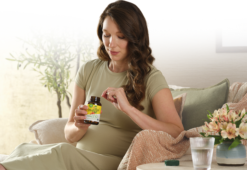 Pregnant woman on a couch with MegaFood Baby & Me 2 Prenatal