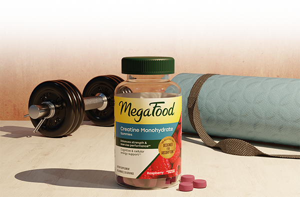 New MegaFood Creatine Monohydrate Gummies on a gym floor with a yoga mat and weights