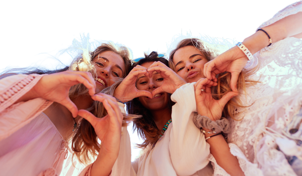 Three women making hearts with their hands