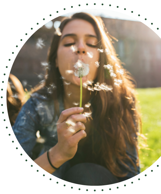 Woman blowing a dandelion