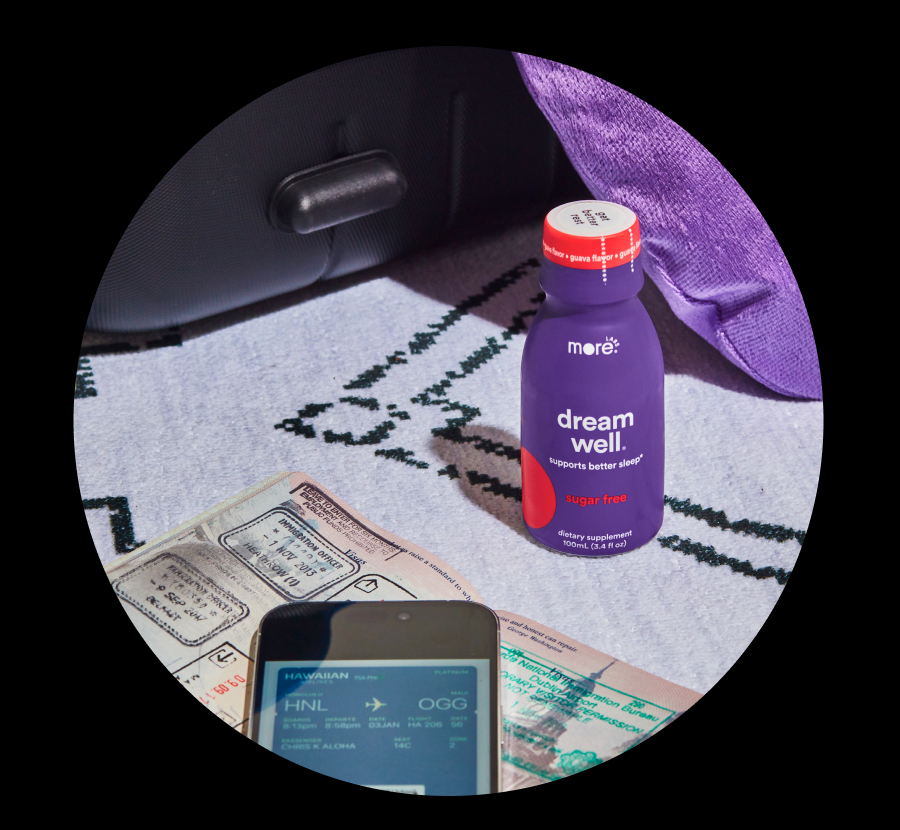 Dream Well bottle, next to suitcase, passport and boarding pass. 