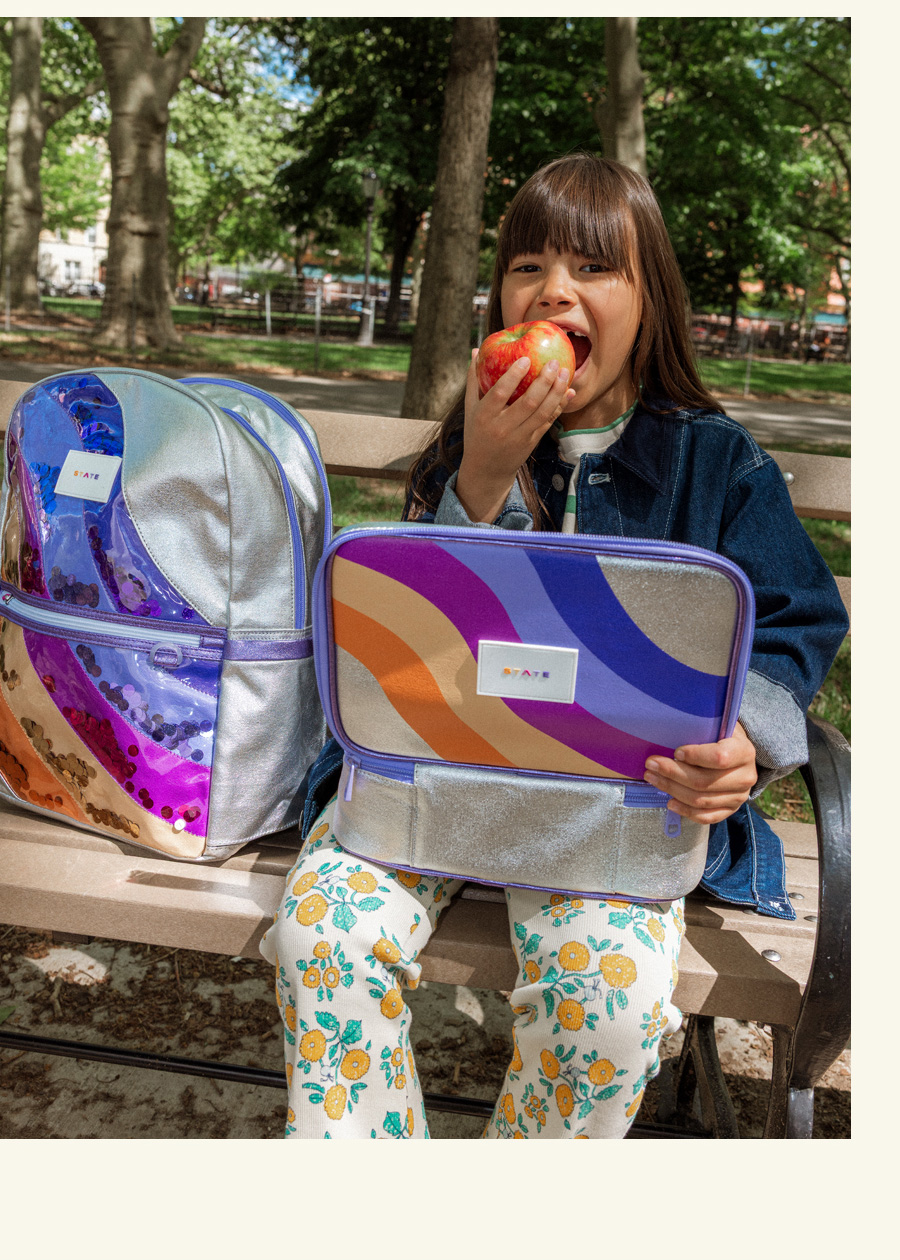 girl sitting with STATE Bags best selling backpack and lunch box