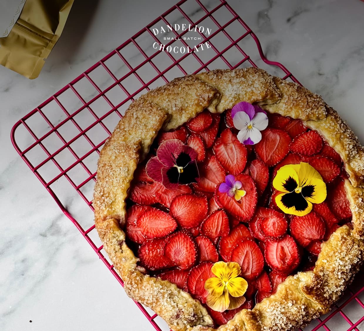 A Dandelion Chocolate Strawberry Galette, which tops chocolate ganache with sliced strawberries and a few edible flowers.