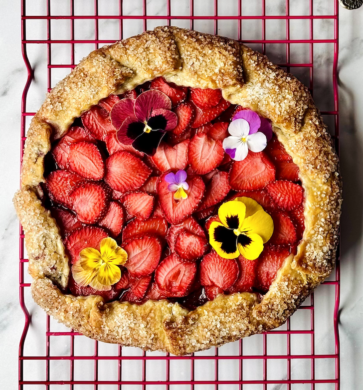 A Dandelion Chocolate Strawberry Galette on a red cooling rack.