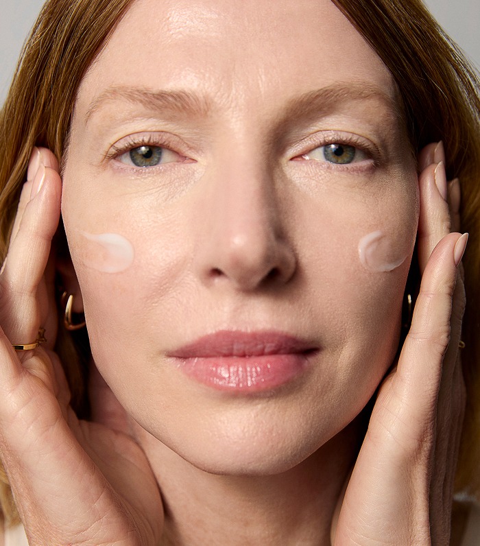 A model applying healthy-aging Tatcha products onto her skin
