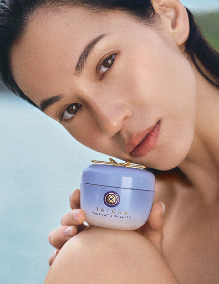An image of a model holding The Dewy Skin Cream by Tatcha
