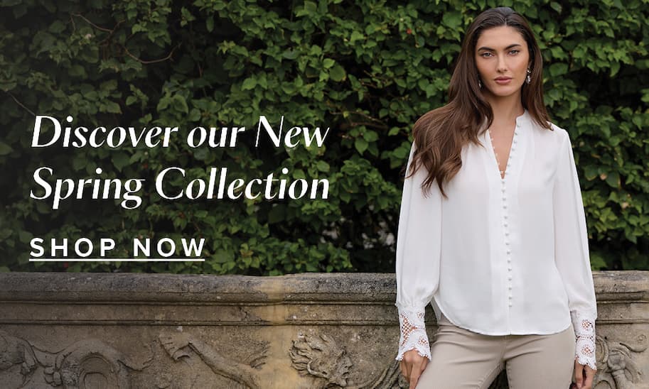 Discover Our New Spring Collection. Shop Now. An image of a model wearing the White Blake Lace Sleeve Blouse and the Oatmeal Nina Cropped Skinny Jean in front of a lush hedge fence and stone ledge.