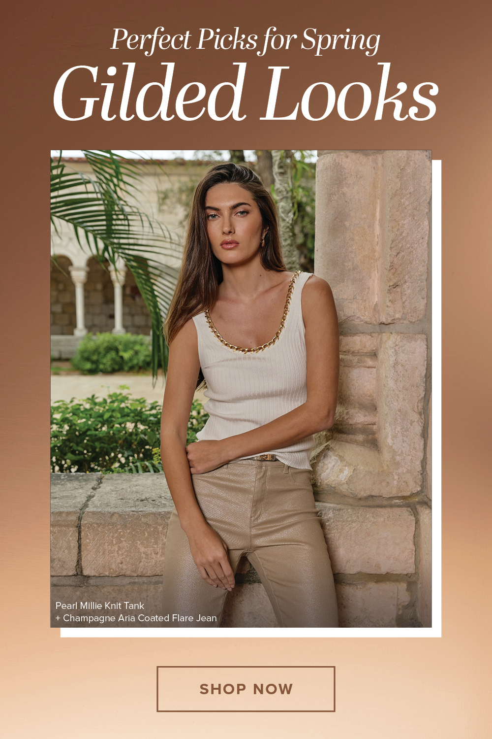 Perfect Picks for Spring. Gilded Looks. An image of a model standing posed wearing the Pearl Millie Knit Tank and the Champagne Aria Coated Flare Jean standing in front of a stone archway in front of a lush garden, the image is imposed in front of a shining golden gradient background. Shop Now.