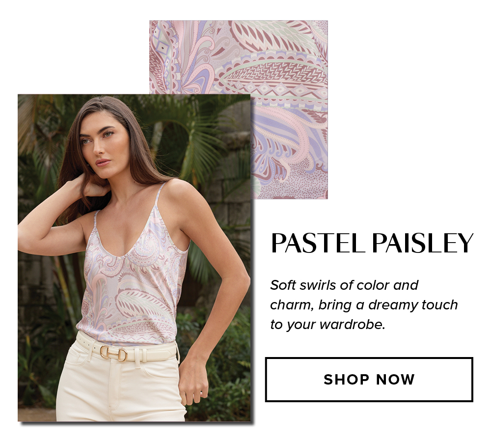 Pastel Paisley. Soft swirls of color and charm, bring a dreamy touch to your wardrobe. An image of a model wearing the Yara Silk Camisole in Pastel Paisley outside in a garden in front of palm trees.