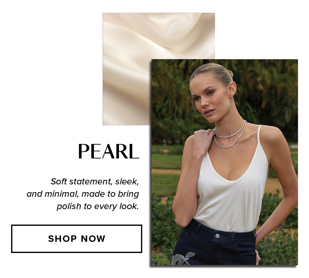 Pearl. Soft statement, sleek, and minimal, made to bring polish to every look. An image of a model wearing the Yara Silk Camisole in Pearl outside in a garden.