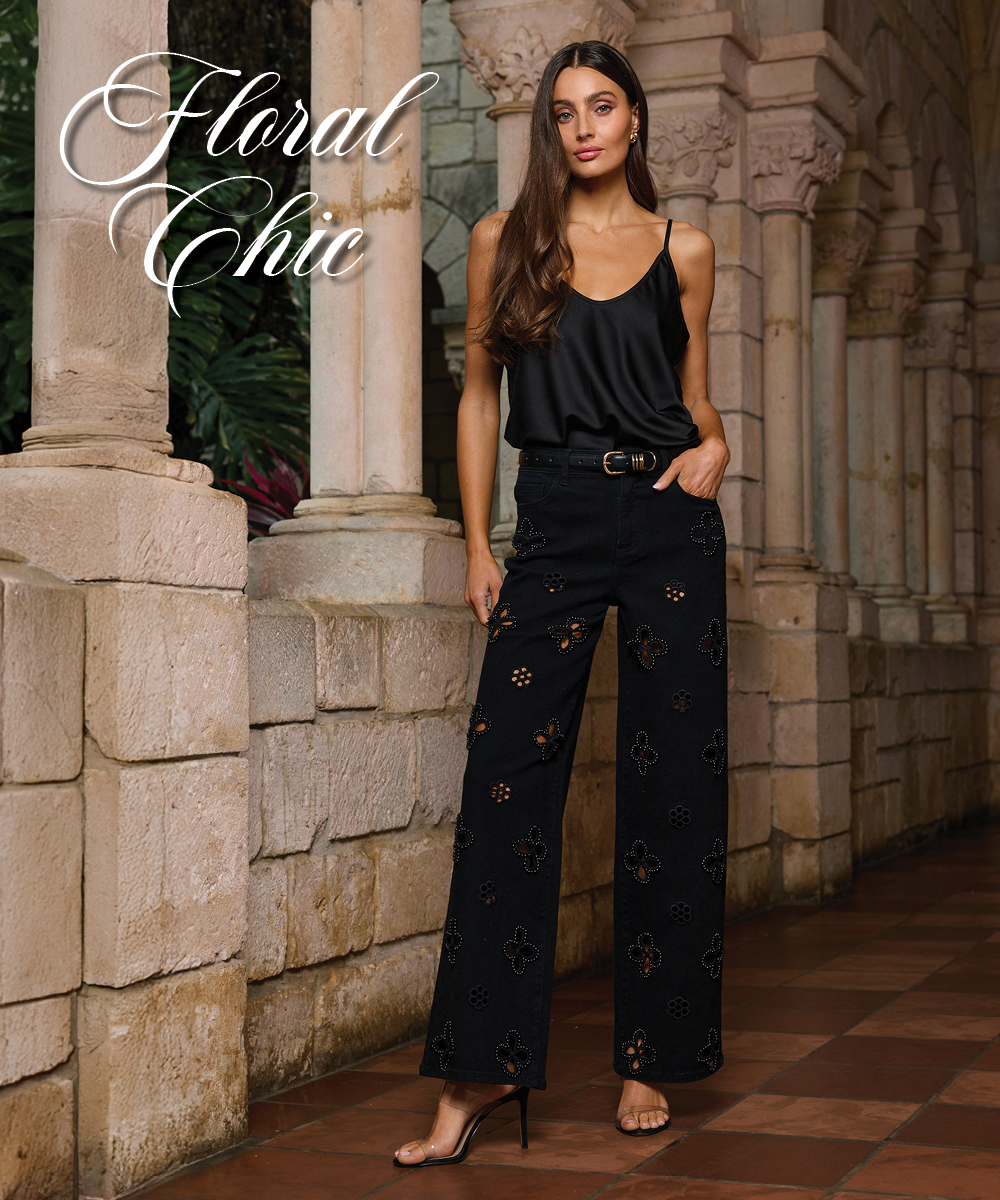 Floral Chic written in decorative cursive. An image of a model posed in the Black Yara Silk Camisole and the Black Kaia Pearl High Rise Jean in a stone corridor. 