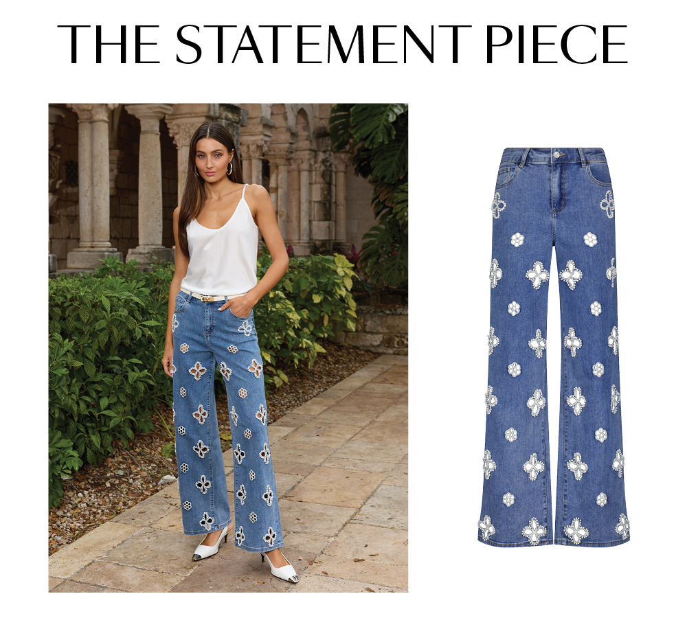 The Statement Piece. A model standing posed with lush greenery behind her. She is wearing the Pearl Yara Silk Camisole and the Medium Blue Kaia Pearl High Rise Jean. A flat composition of the jean is beside the image.