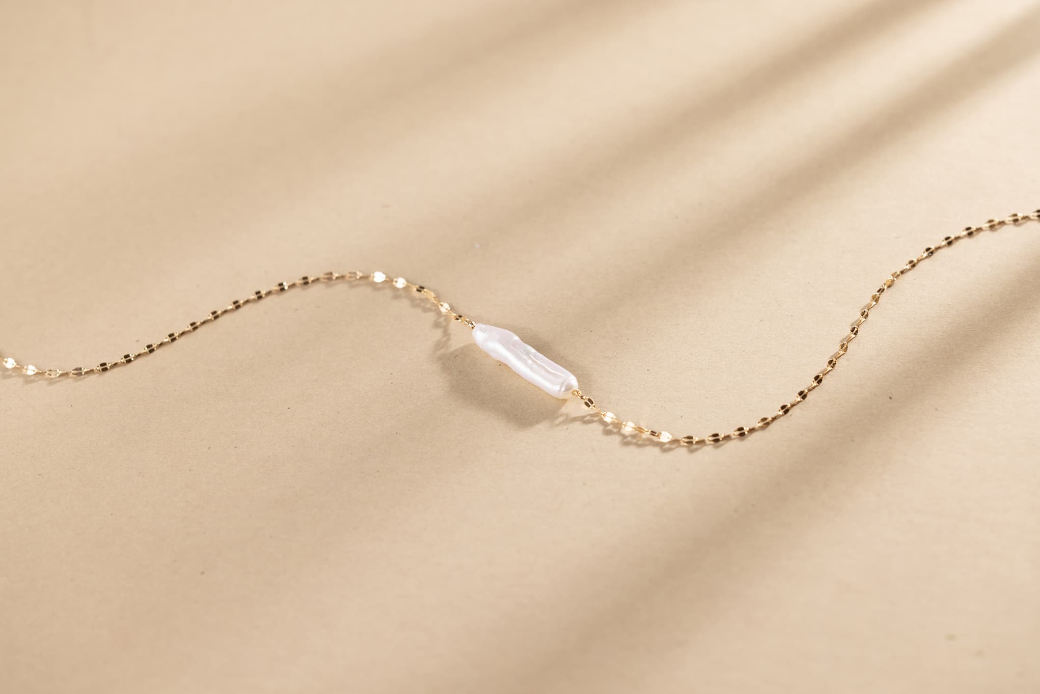 Delicate gold chain with baroque pearl, bridal jewelry flatlay