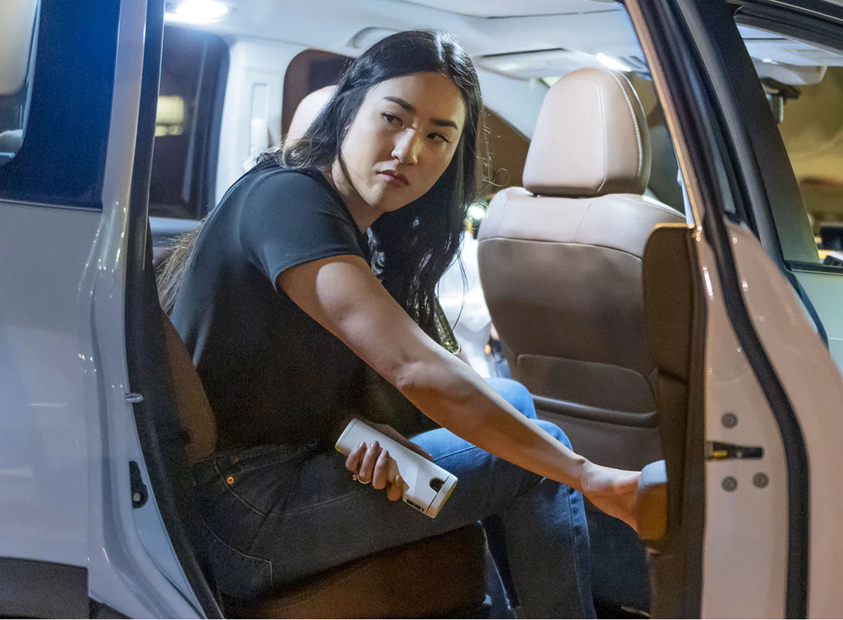 woman getting out of car holding Taser Bolt 2