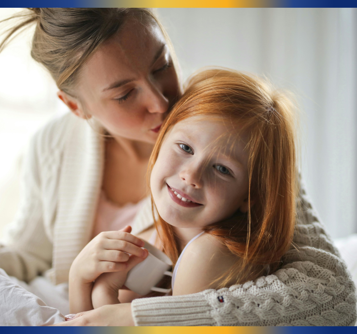 mom kissing her daughter on the head