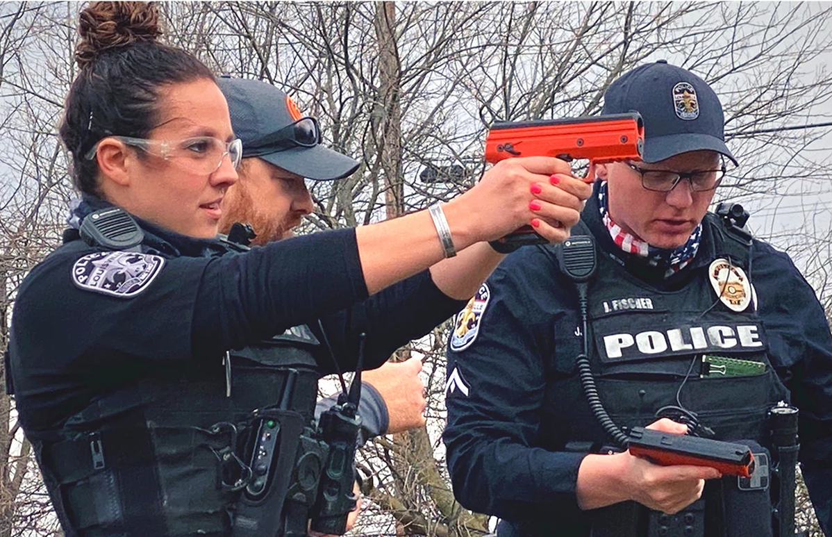 policewoman using a Byrna projectile gun