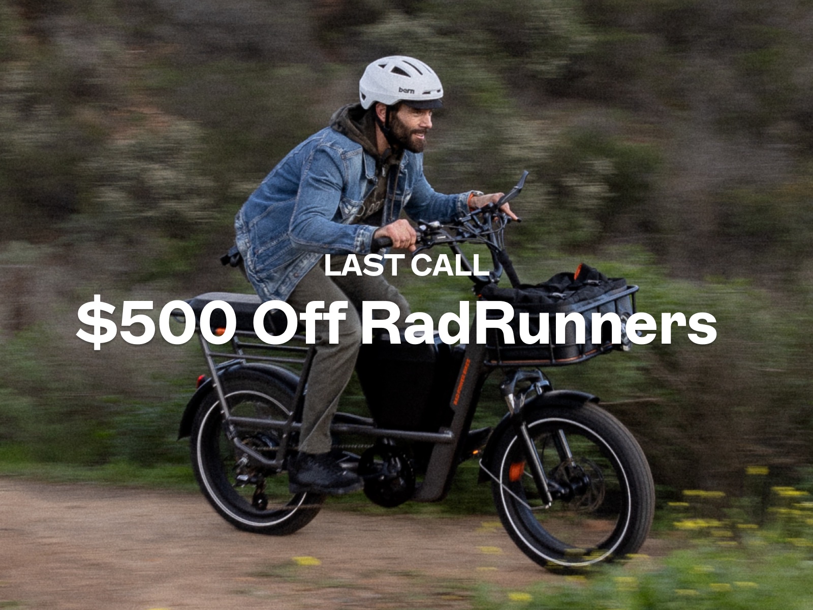 A man rides a dark grey electric bike on a rural trail