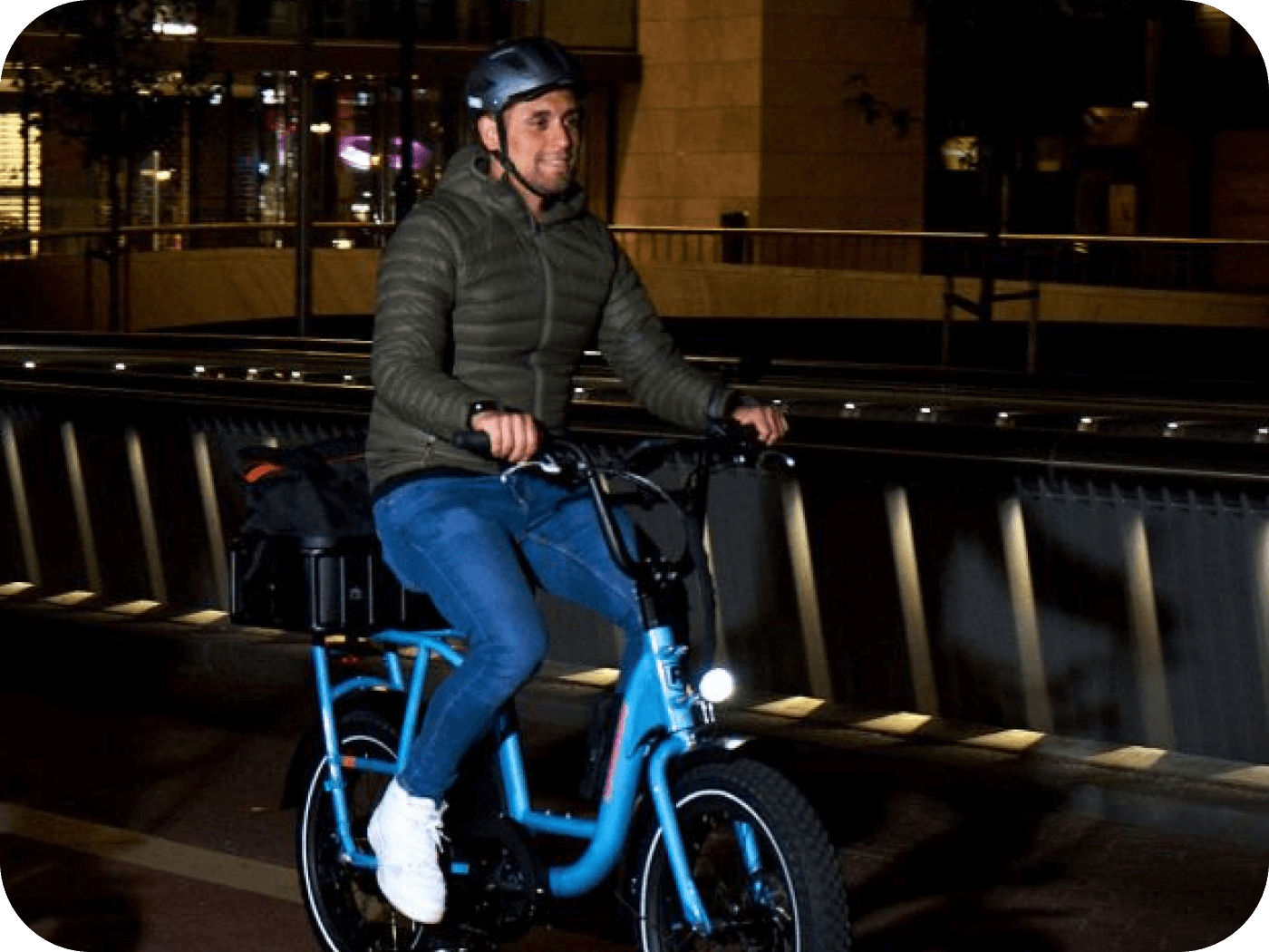 Person riding a pool shark blue ebike at night