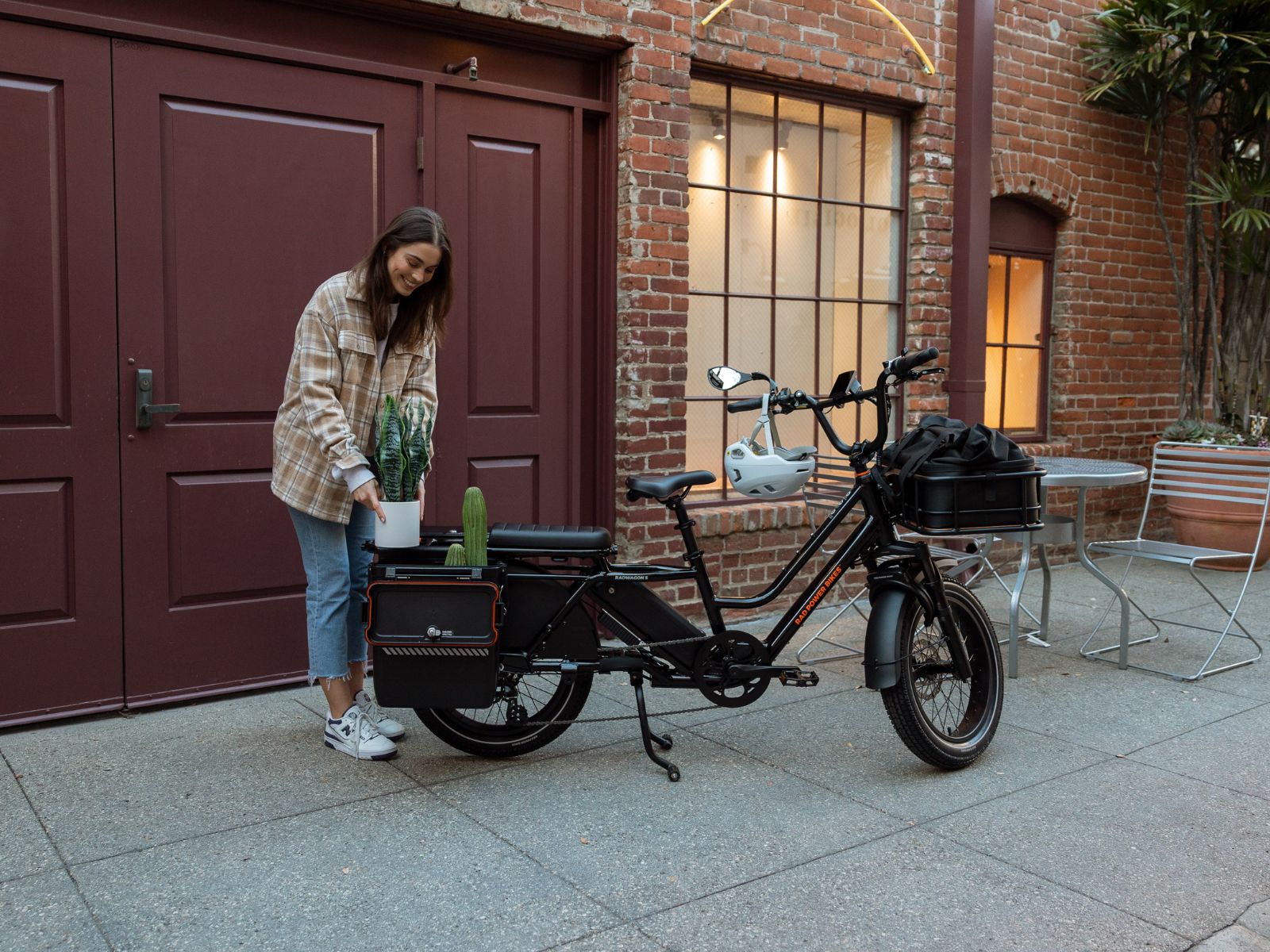 A green fat tire electric bike with a rear basket on rocks in a forest setting.