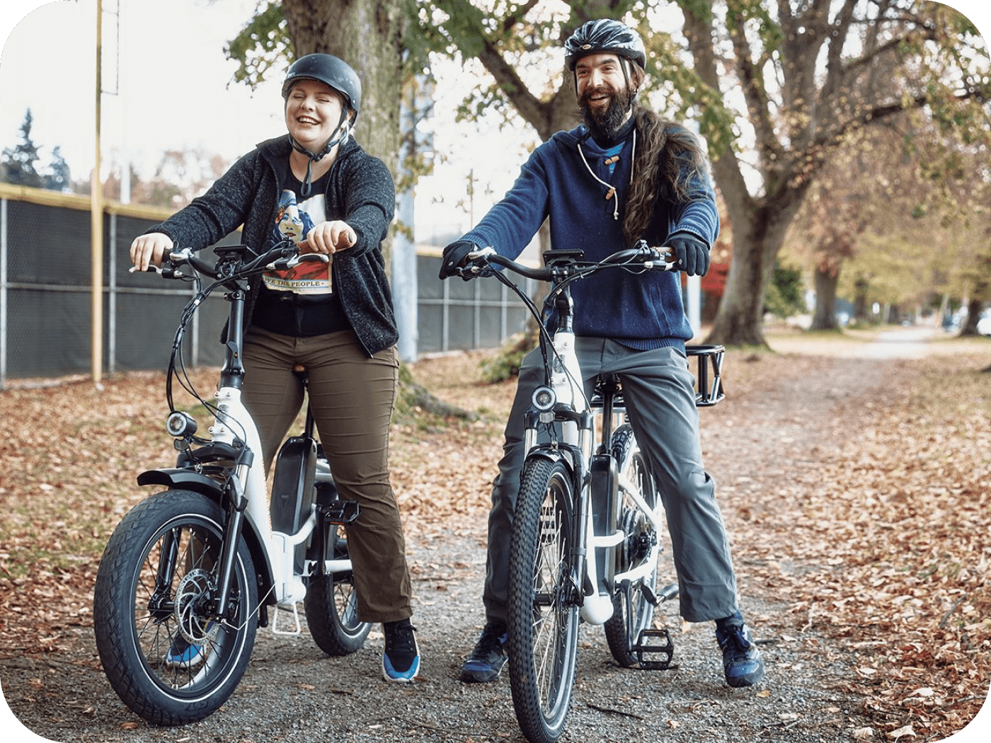 Two people riding ebikes outdoors