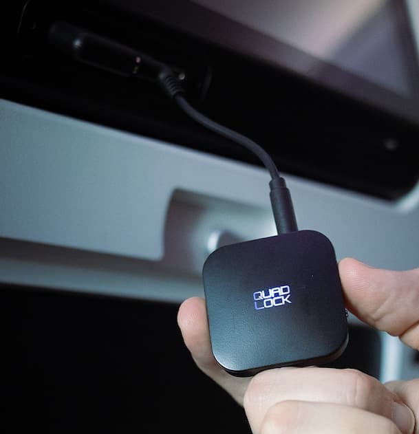 A photo of connecting a plane screen with the Quad Lock AUX Bluetooth Adaptor