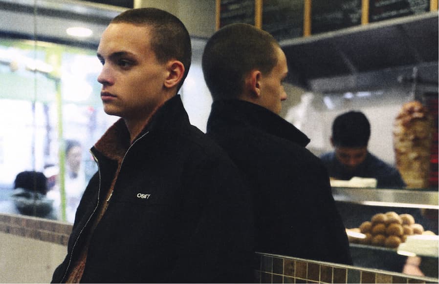 Men model standing in a doner shop wearing fall collection