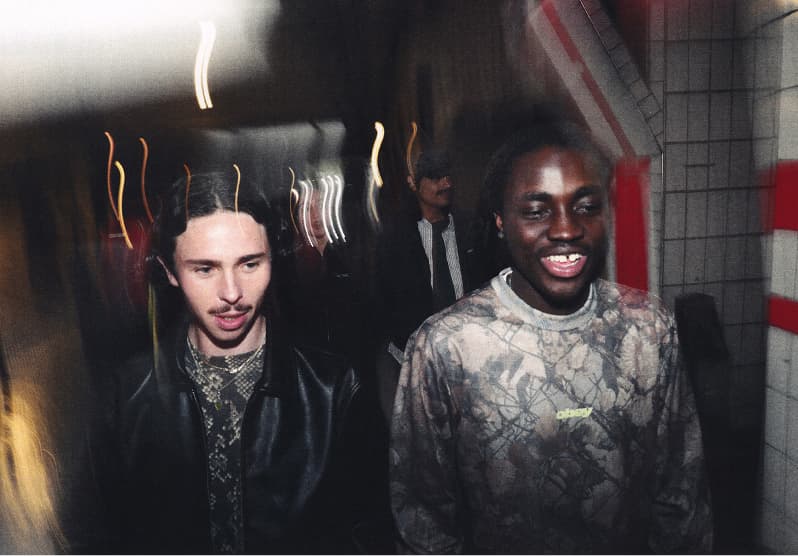 Two men model waiting in line wearing Obey fall 2026 collection