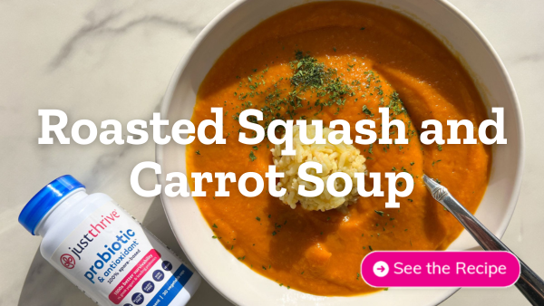 Image of roasted squash and carrot soup in a bowl next to bottle of Just Thrive Probiotic