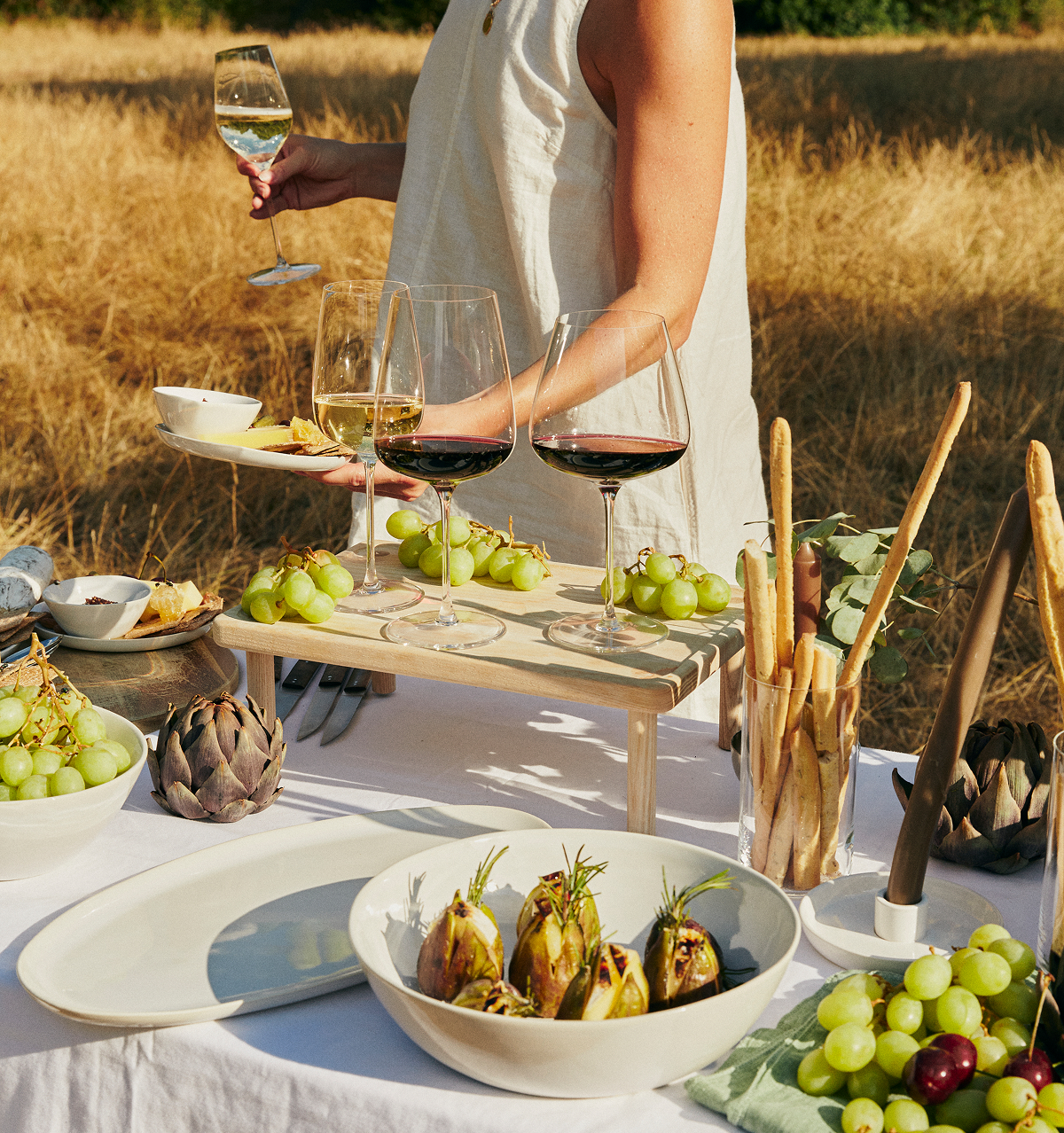 Our first table is set, and it’s anywhere but ordinary: in a golden field, bathed in afternoon light, laid with a seasonal spread and glasses that refill before you ask.