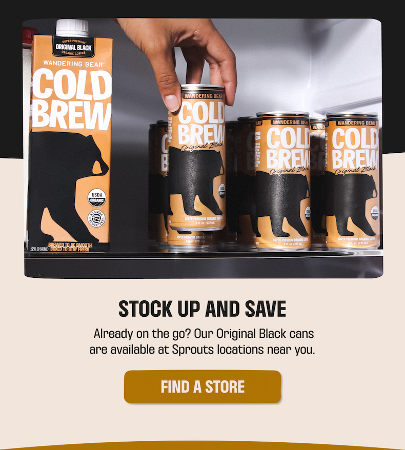 Hand grabbing a Wandering Bear Cold Brew Original Black can from a fridge stocked with cans and cartons - find a store near you