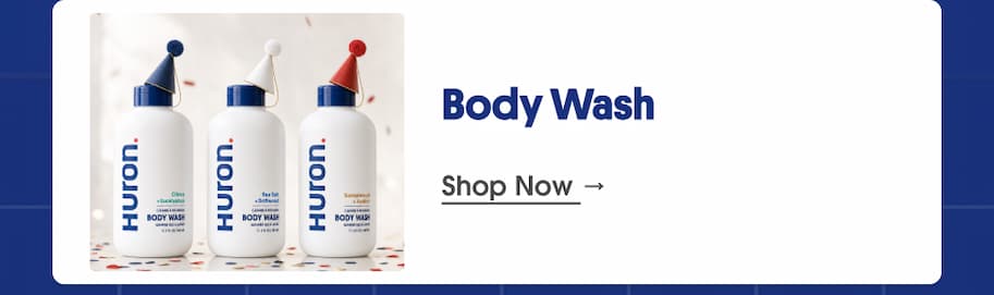 Three Huron body wash bottles wearing party hats on confetti background, next to the heading "Body Wash" and a "Shop Now" link
