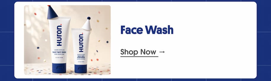 Two Huron face wash and moisturizer tubes wearing party hats on confetti background, next to the heading "Face Wash" and a "Shop Now" link