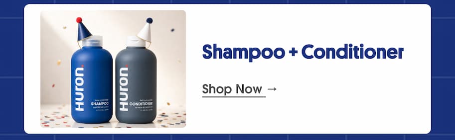 Huron shampoo and conditioner bottles wearing party hats on confetti background, next to the heading "Shampoo + Conditioner" and a "Shop Now" link