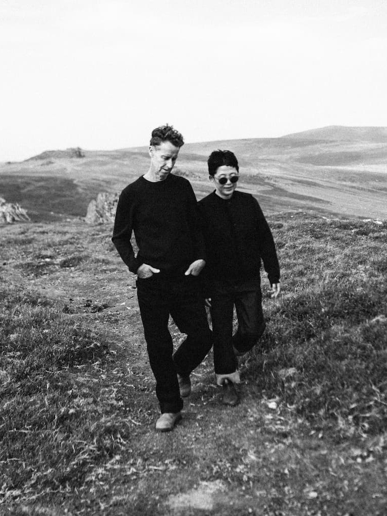 A couple walking on a field.