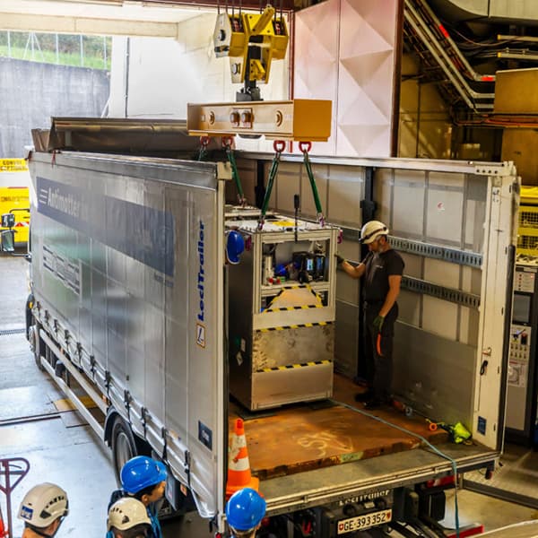 image of person loading on technology to hold anti protons into back of truck.