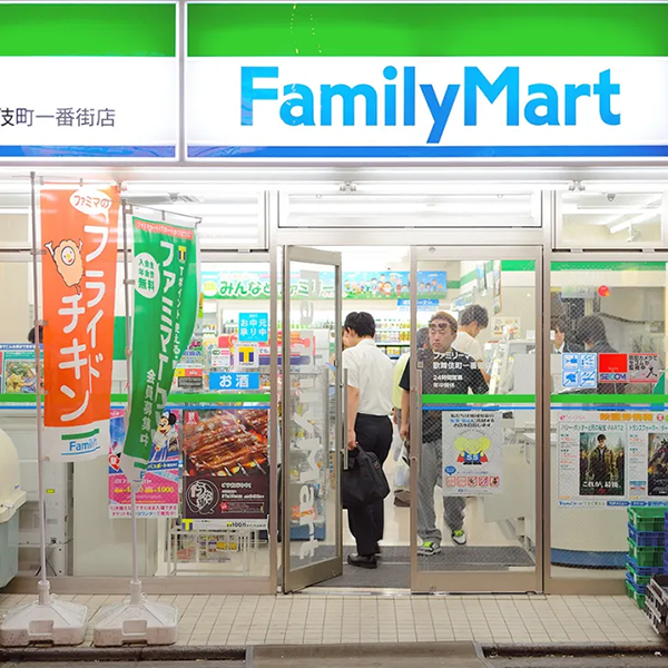 Image of man entering brightly lit 'Family Mart' in Tokyo
