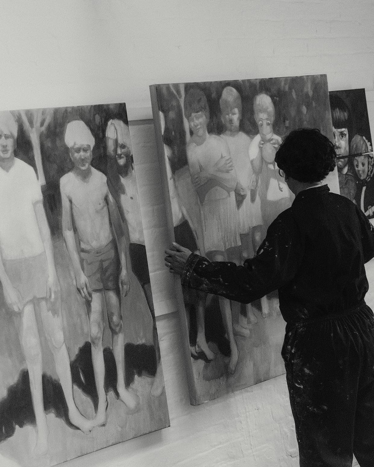 Amy hangs a triptych on her studio wall.
