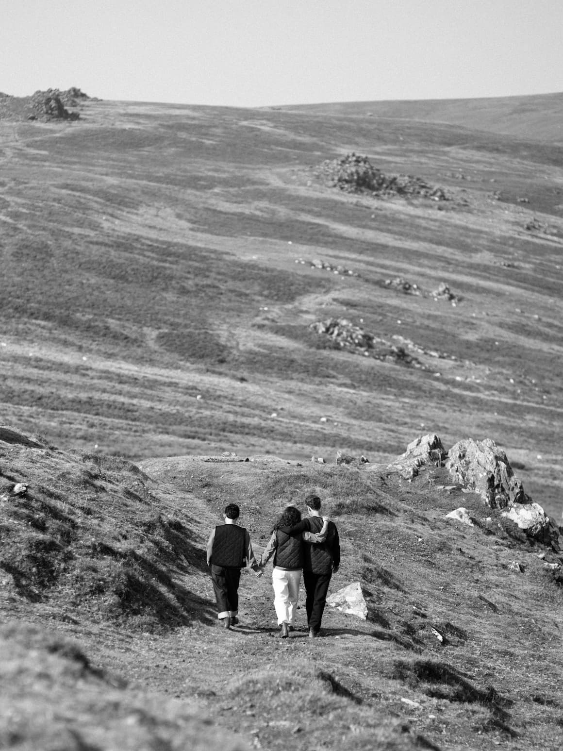 3 people walking in a distant field.