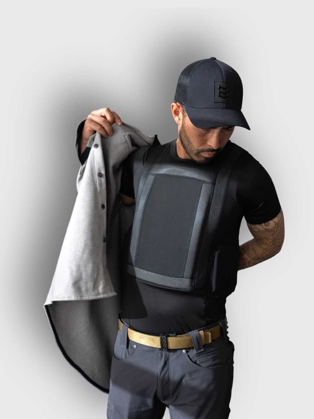 man putting jacket on over black armor under shirt man putting jacket on over black armor under shirt