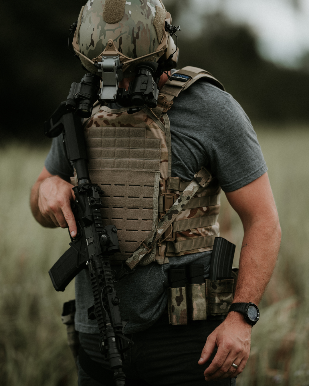 man wearing camo plate carrier with duty belt and tactical helmet