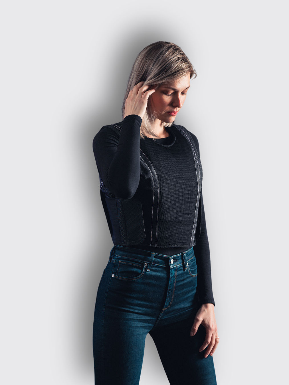 woman in jeans, black shirt, and black concealable armor vest woman in jeans, black shirt, and black concealable armor vest