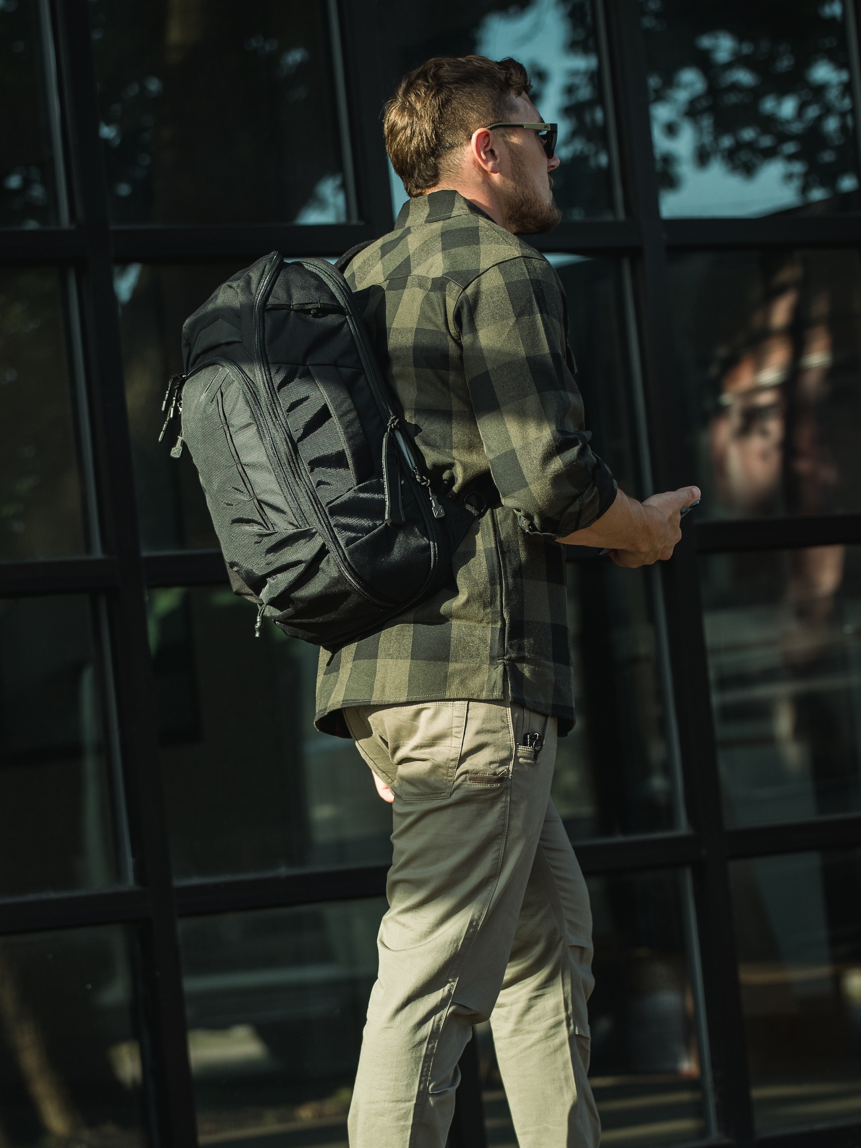 man outside wearing vertx gamut backpack in grey