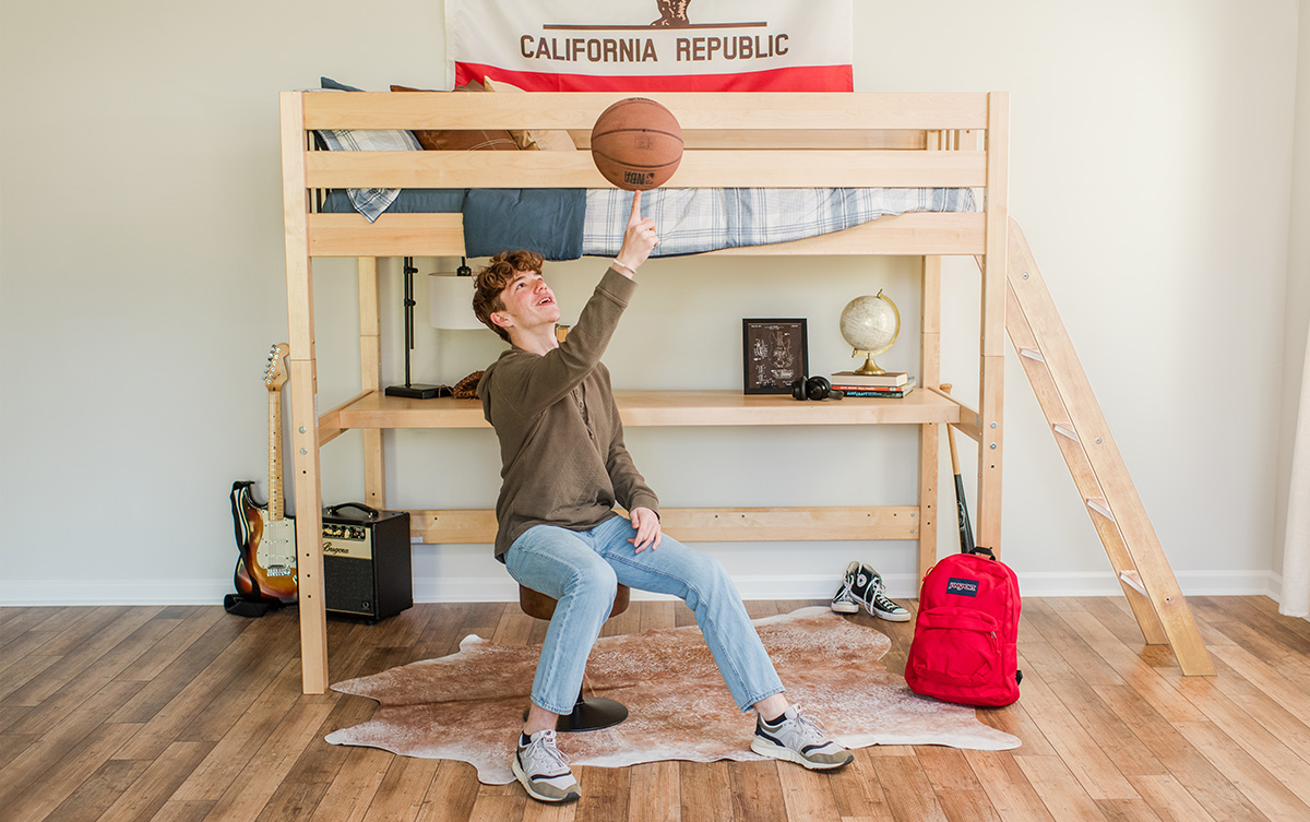 Teen sitting in front of a lofted bed