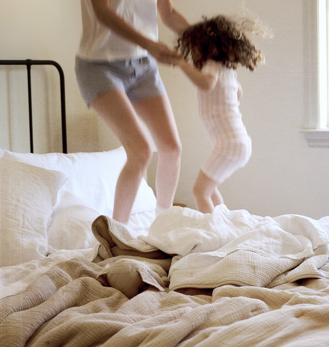 Mother and daughter jumping on bed